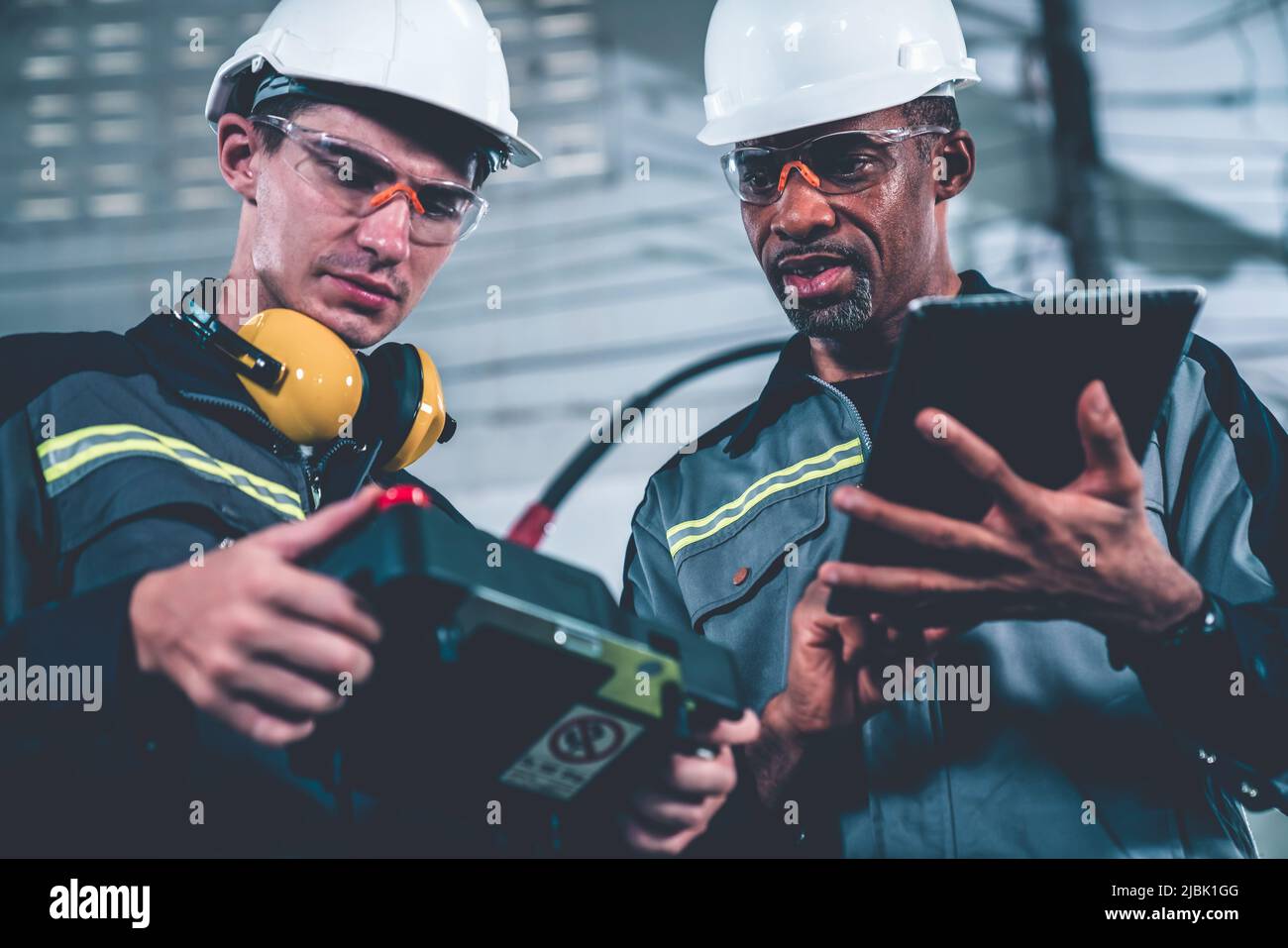 Group of factory job workers using adept machine equipment in a
