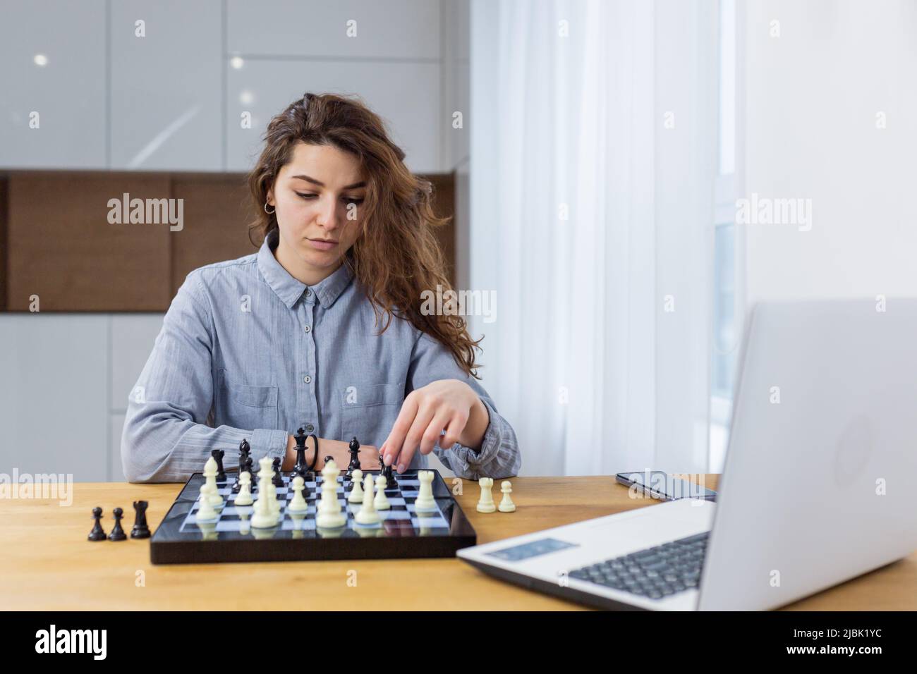 Premium Photo  Girl playing chess online on tablet computer