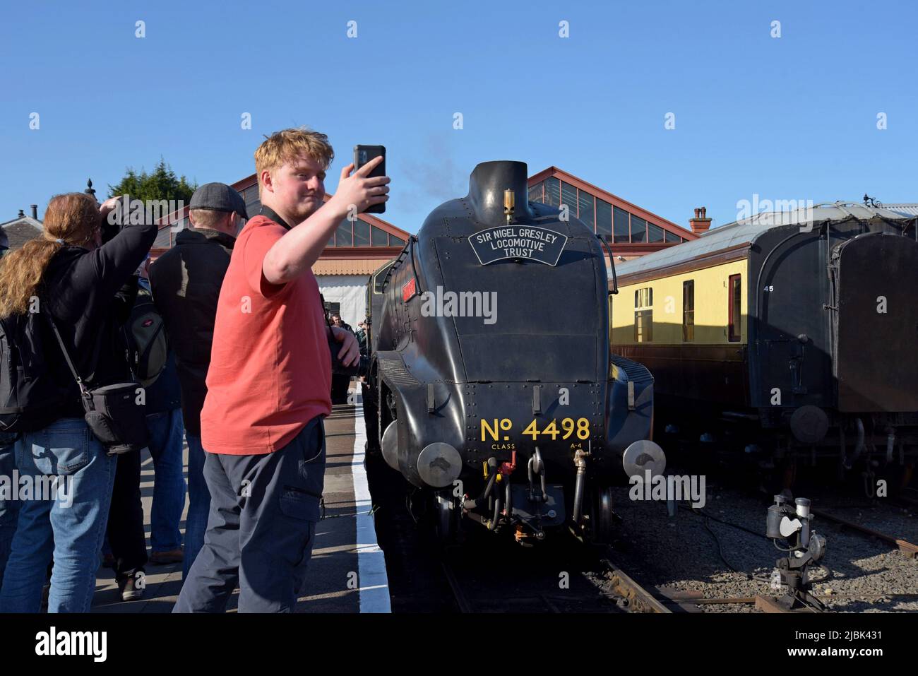 A rail enthusiast takes a selfie with newly restored LNER A4 Pacific 4498 'Sir Nigel Gresley' at Kidderminster Station, Severn Valley Railway, UK - Stock Image