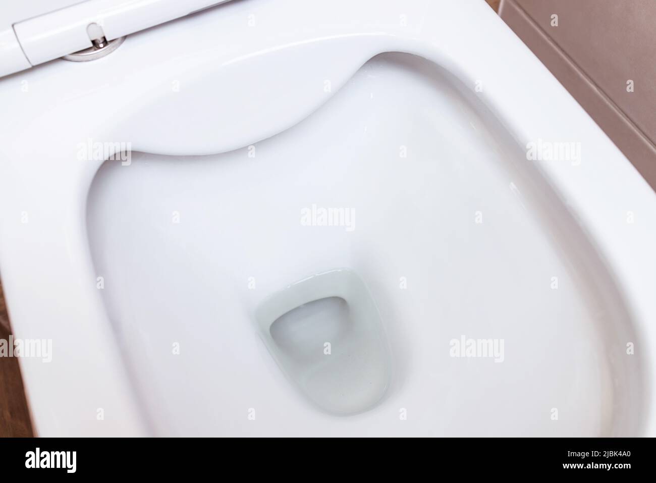 Large modern white toilet closeup. Clean bowl. The concept of hygiene