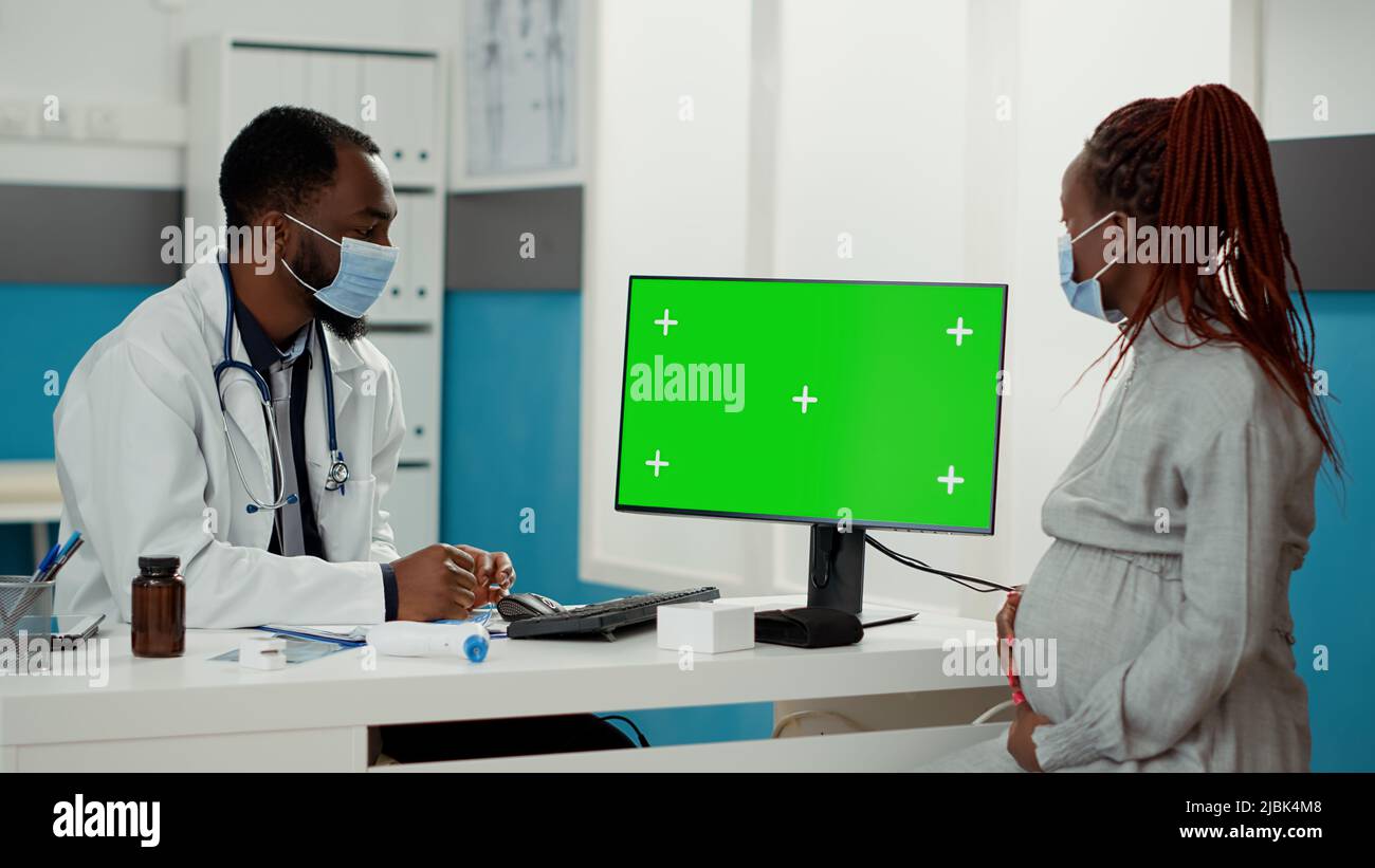 Expectant Person Computer Medic and expectant patient looking at computer with greenscreen at ...