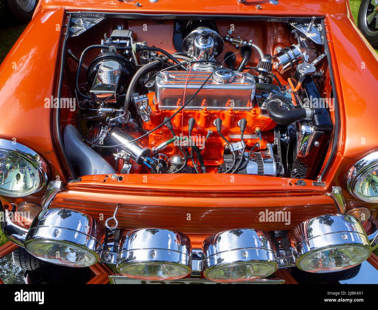 Orange classic Mini with its engine on display Stock Photo