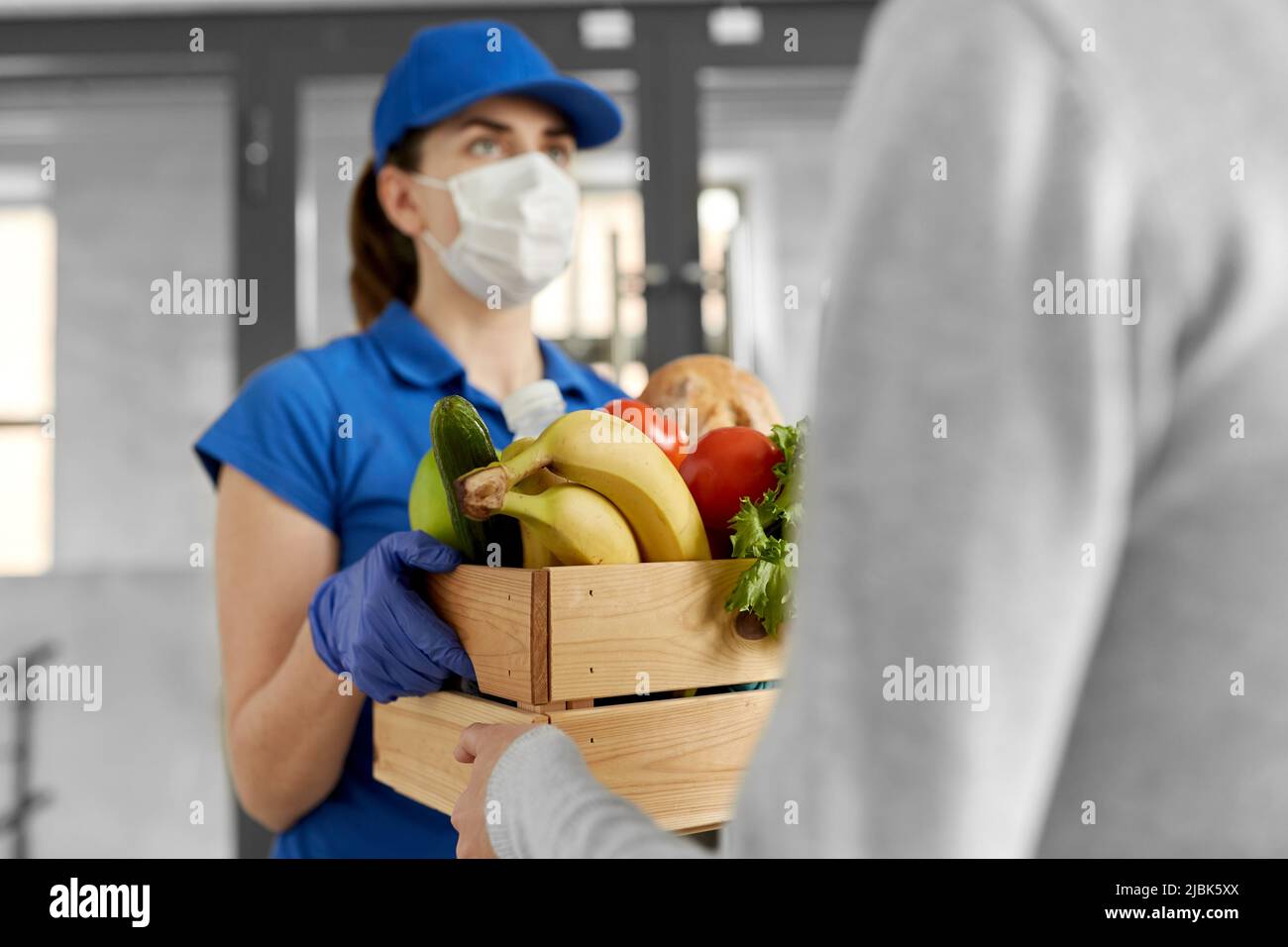 delivery woman in mask giving food to customer Stock Photo - Alamy