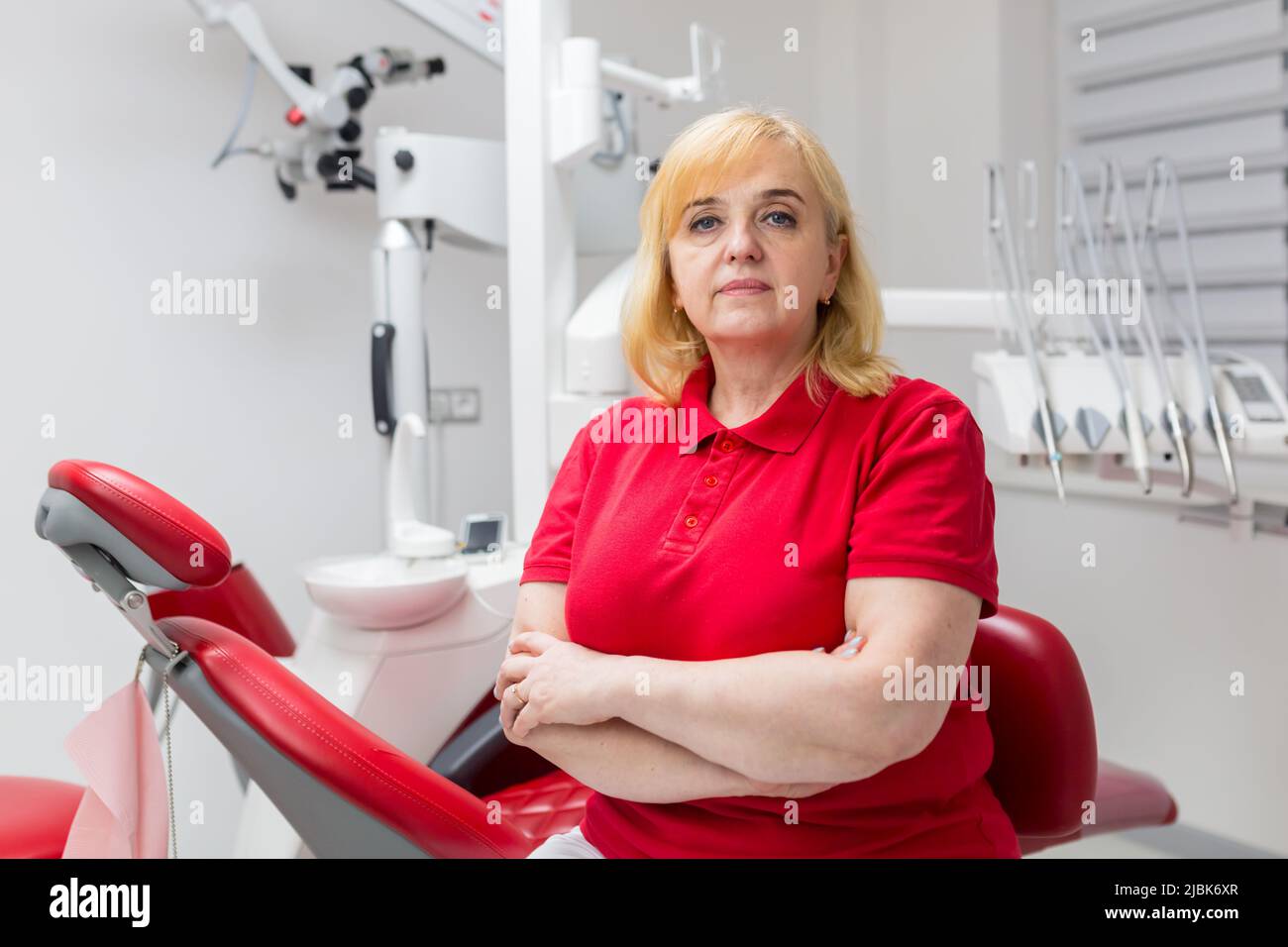Portrait of a young beautiful female dentist, assistant in a red