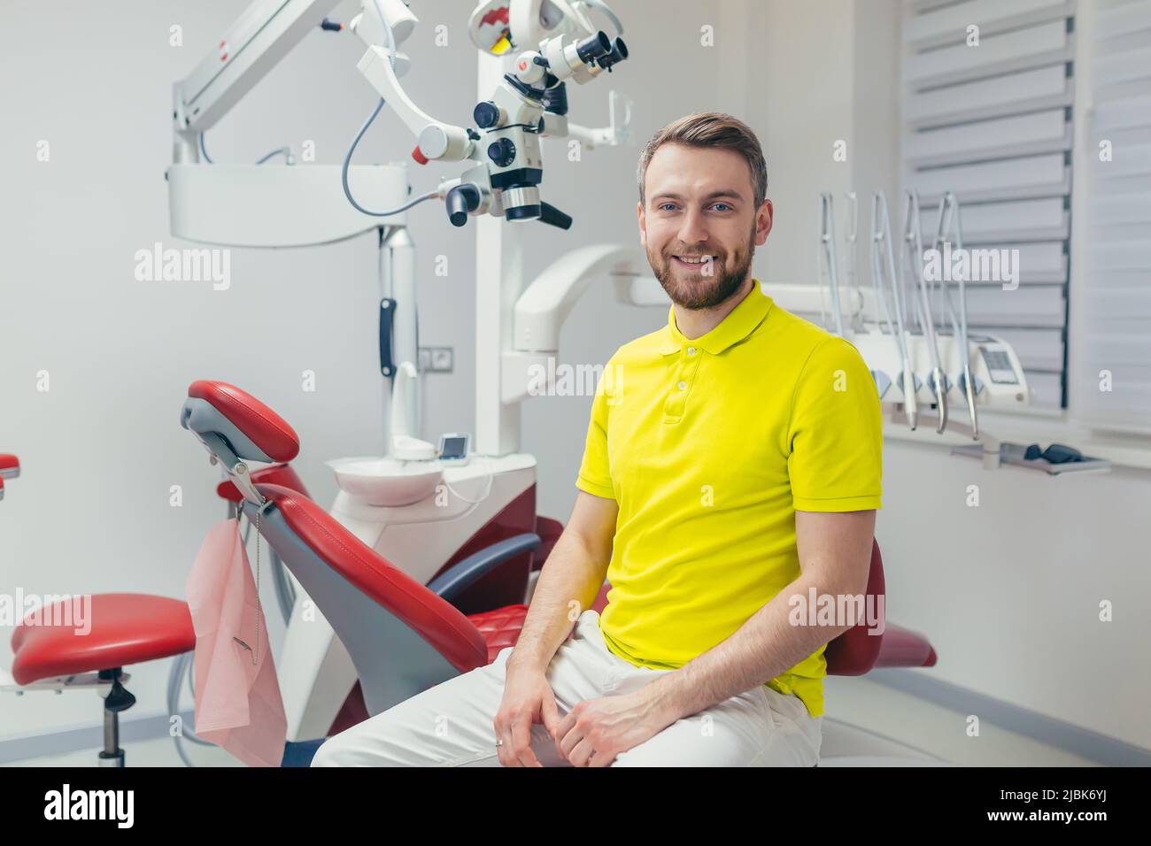 Portrait of a young dentist, assistant in a yellow medical uniform