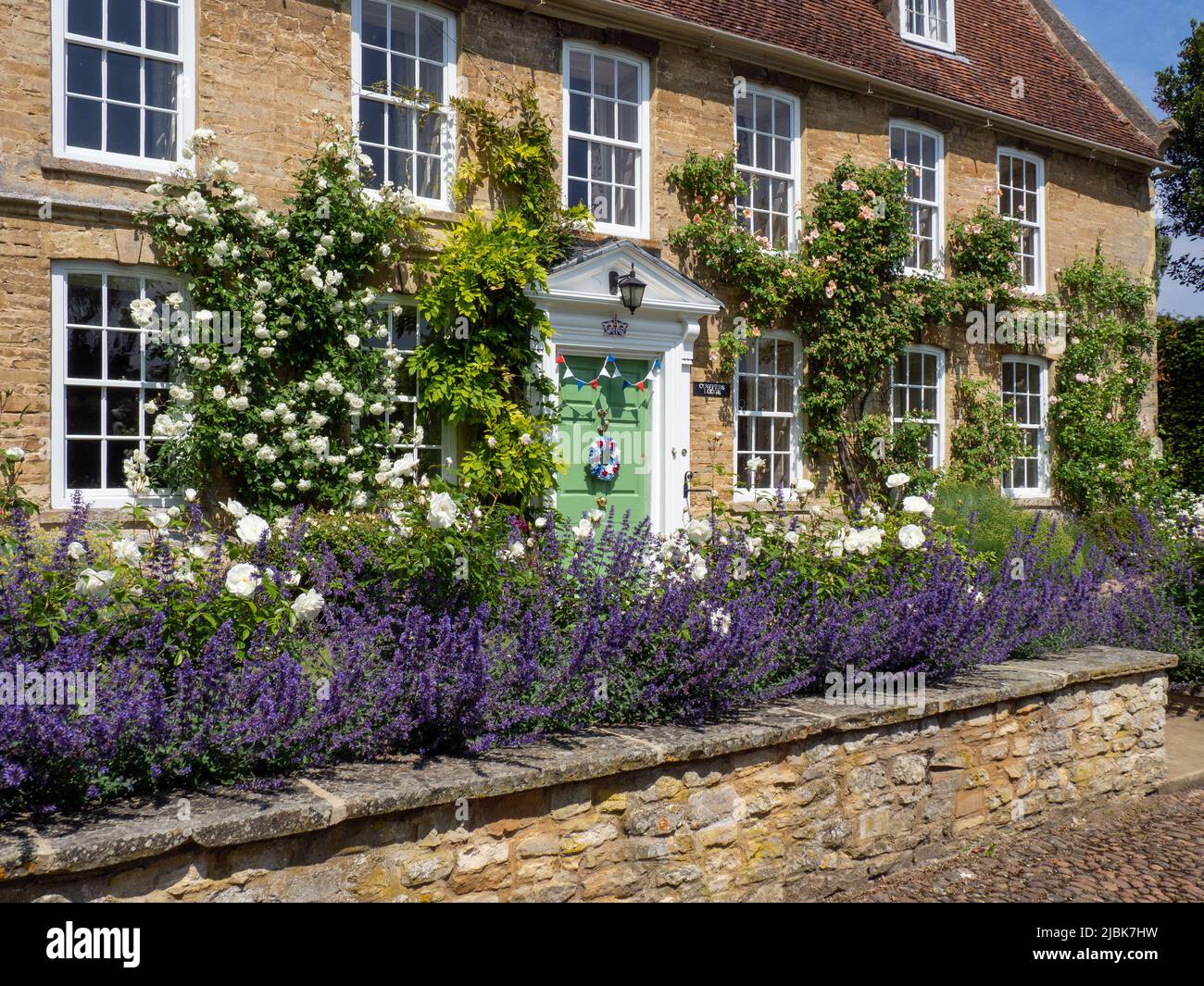 Detached stone built period property with colourful planting and climbers, Weston Underwood, Buckinghamshire, England, UK Stock Photo
