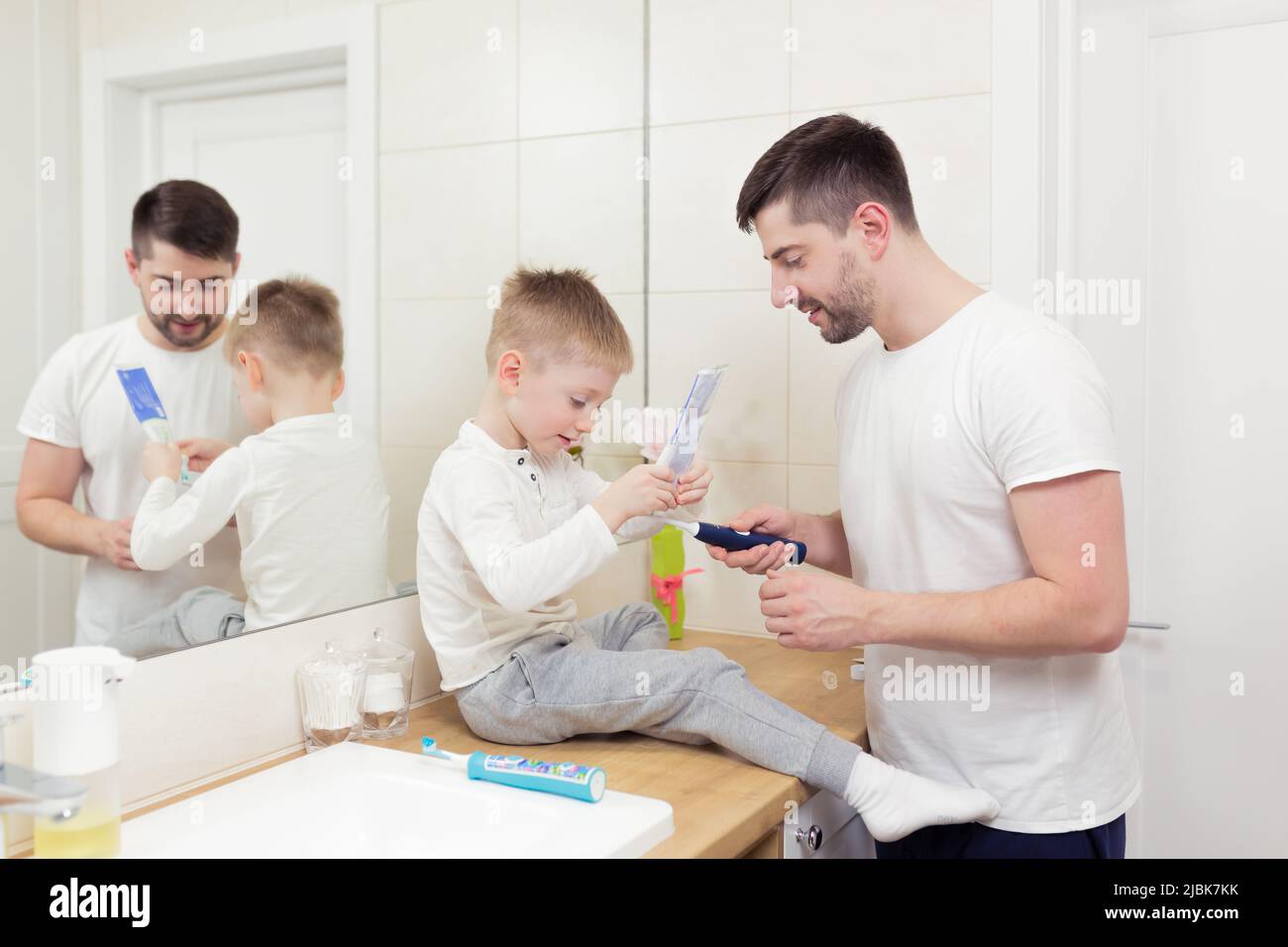 Morning at home, dad with children. Sons wash, brush teeth together in