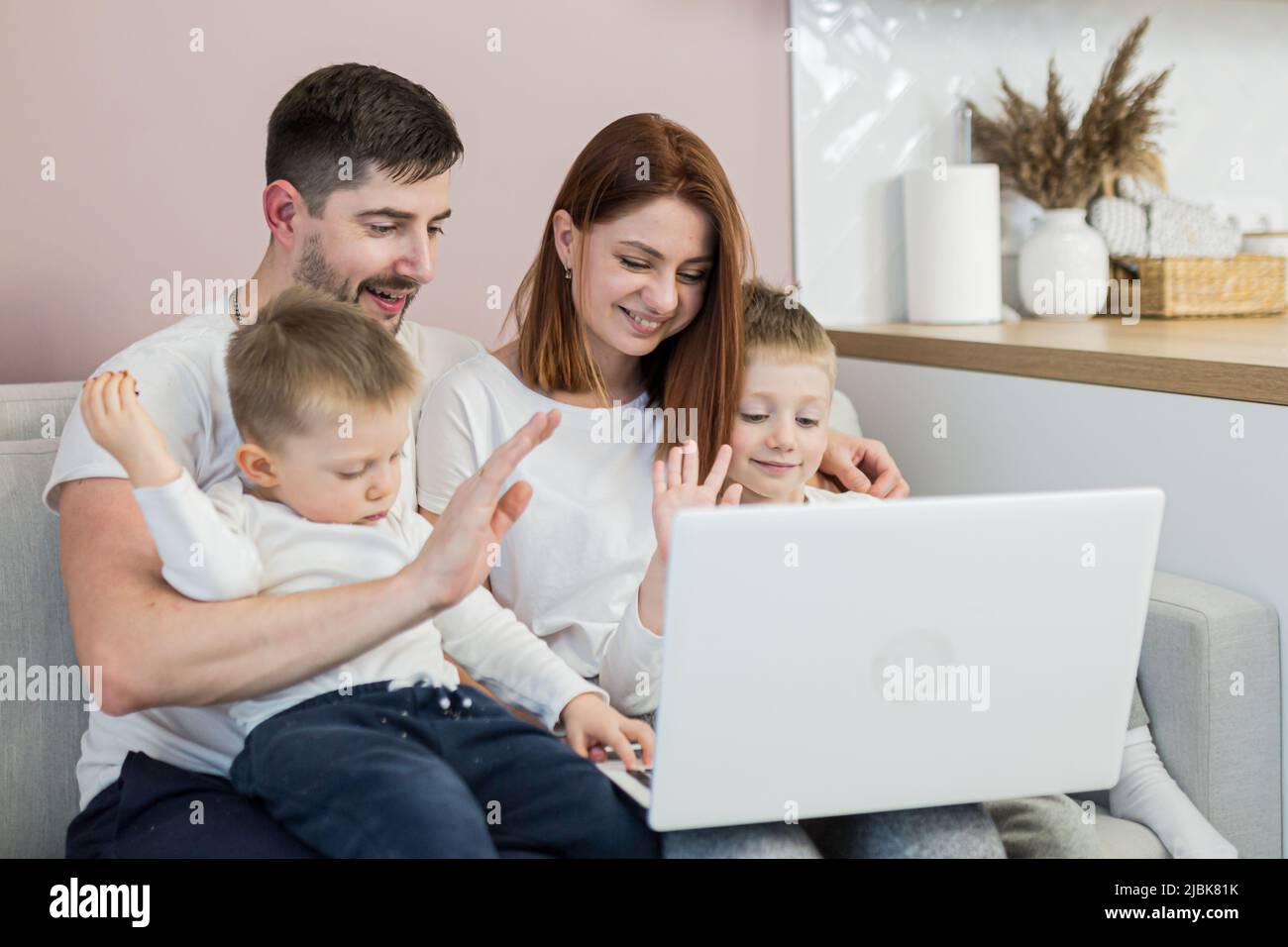 Young family, mom, dad, two children, sitting on the couch at home in ...