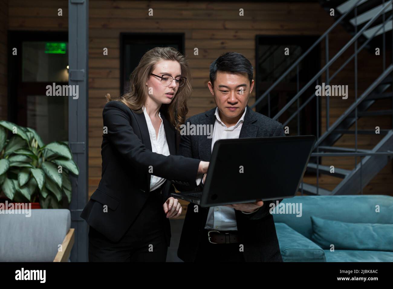 Businesswoman and an Asian investor are negotiating on IT technology ...