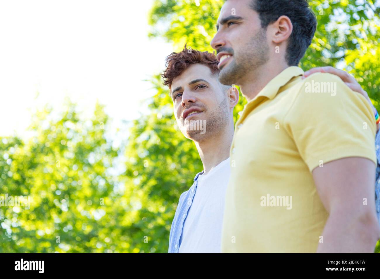 Side view couple of young gay men walking through a park. relationship concept Stock Photo