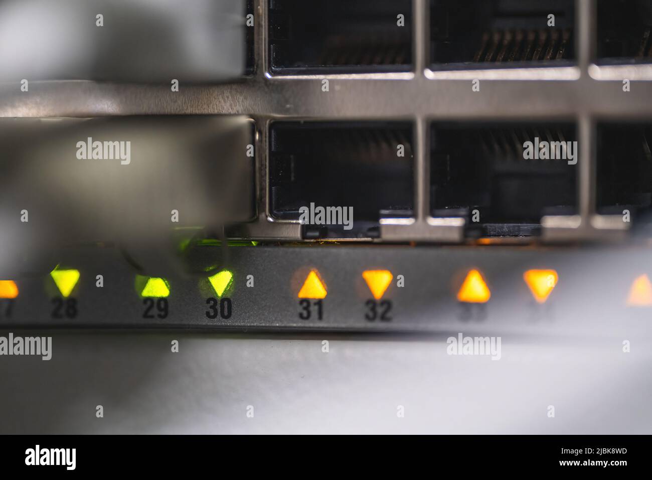 A detail shot of a networking switch with plugged-in cables and indicator led. Stock Photo