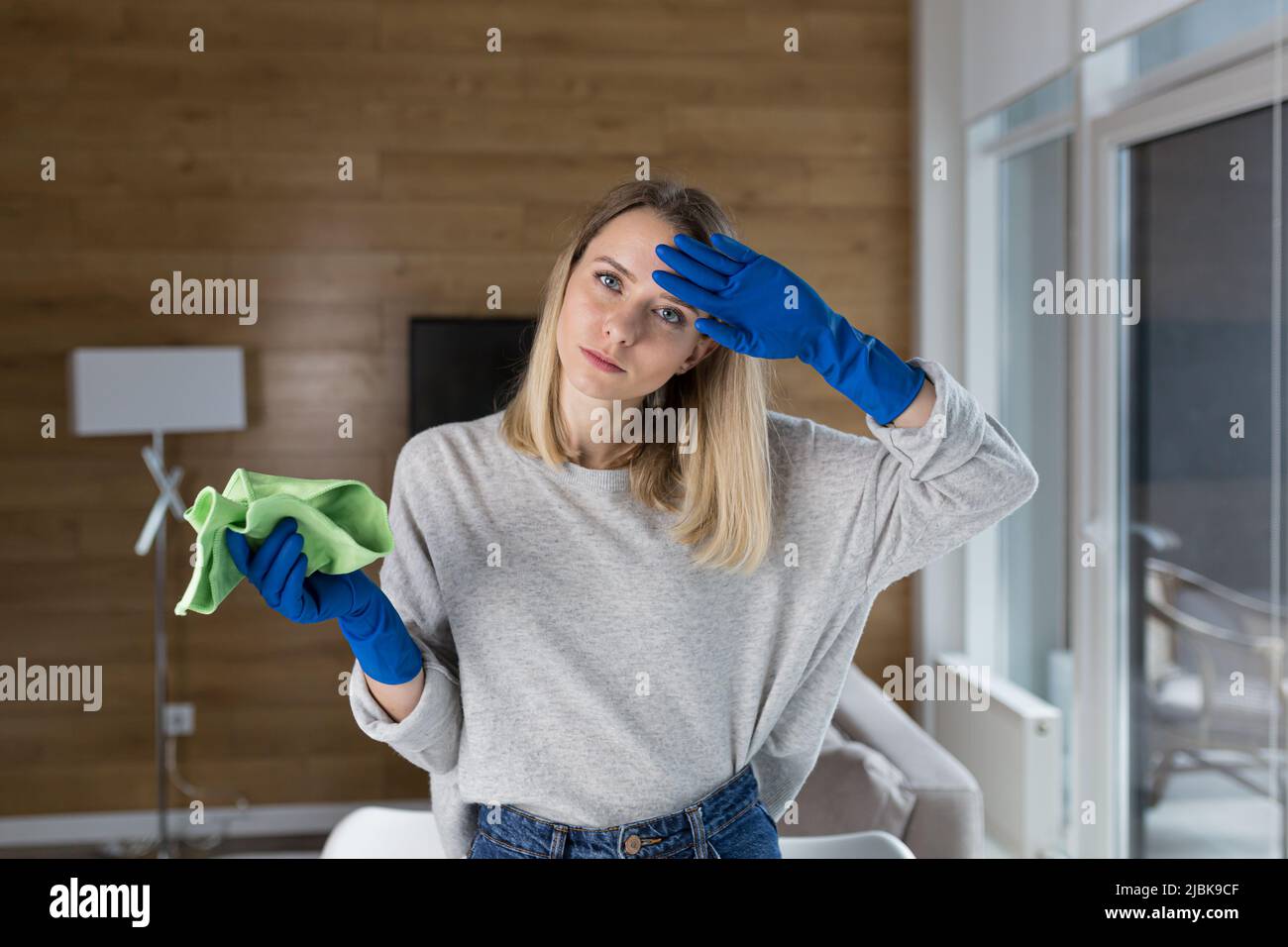 Tired young woman cleans, housewife, washes table with rag in rubber ...