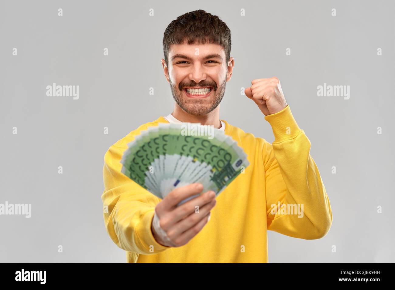 happy young man with money celebrating success Stock Photo