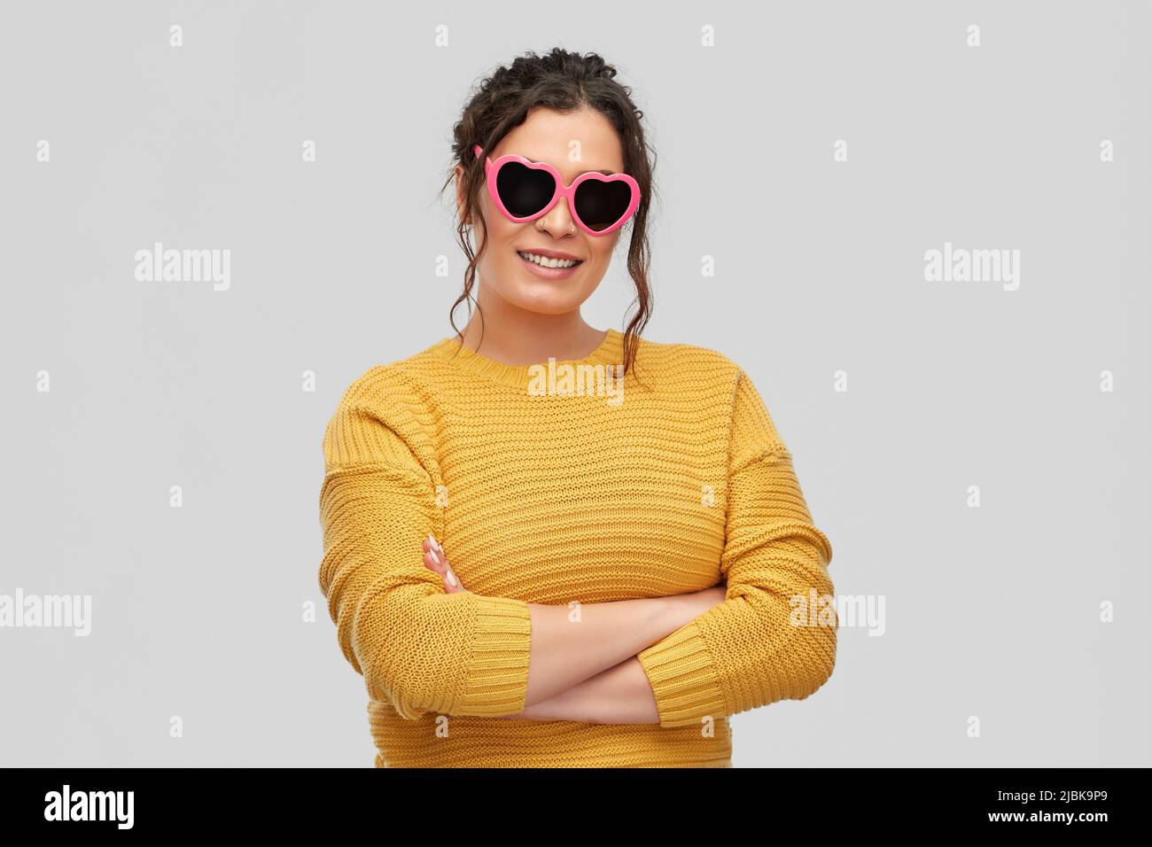smiling young woman in heart-shaped sunglasses Stock Photo