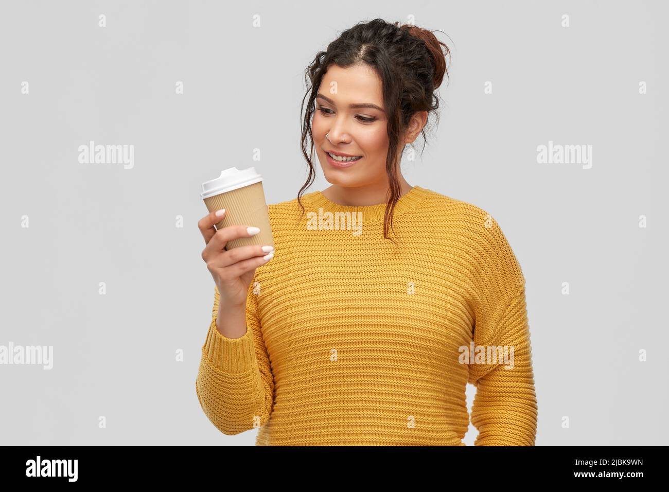 smiling woman with pierced nose holding coffee cup Stock Photo