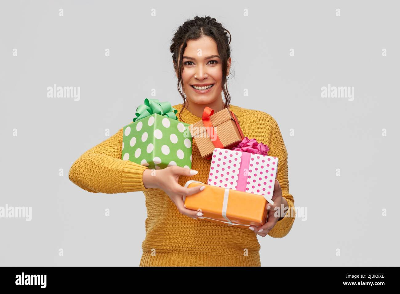 smiling young woman holding gift boxes Stock Photo