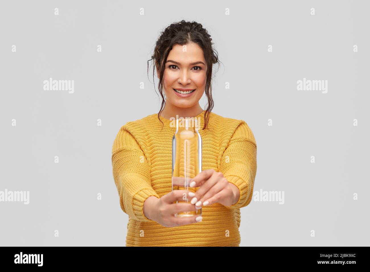 smiling young woman with water in glass bottle Stock Photo