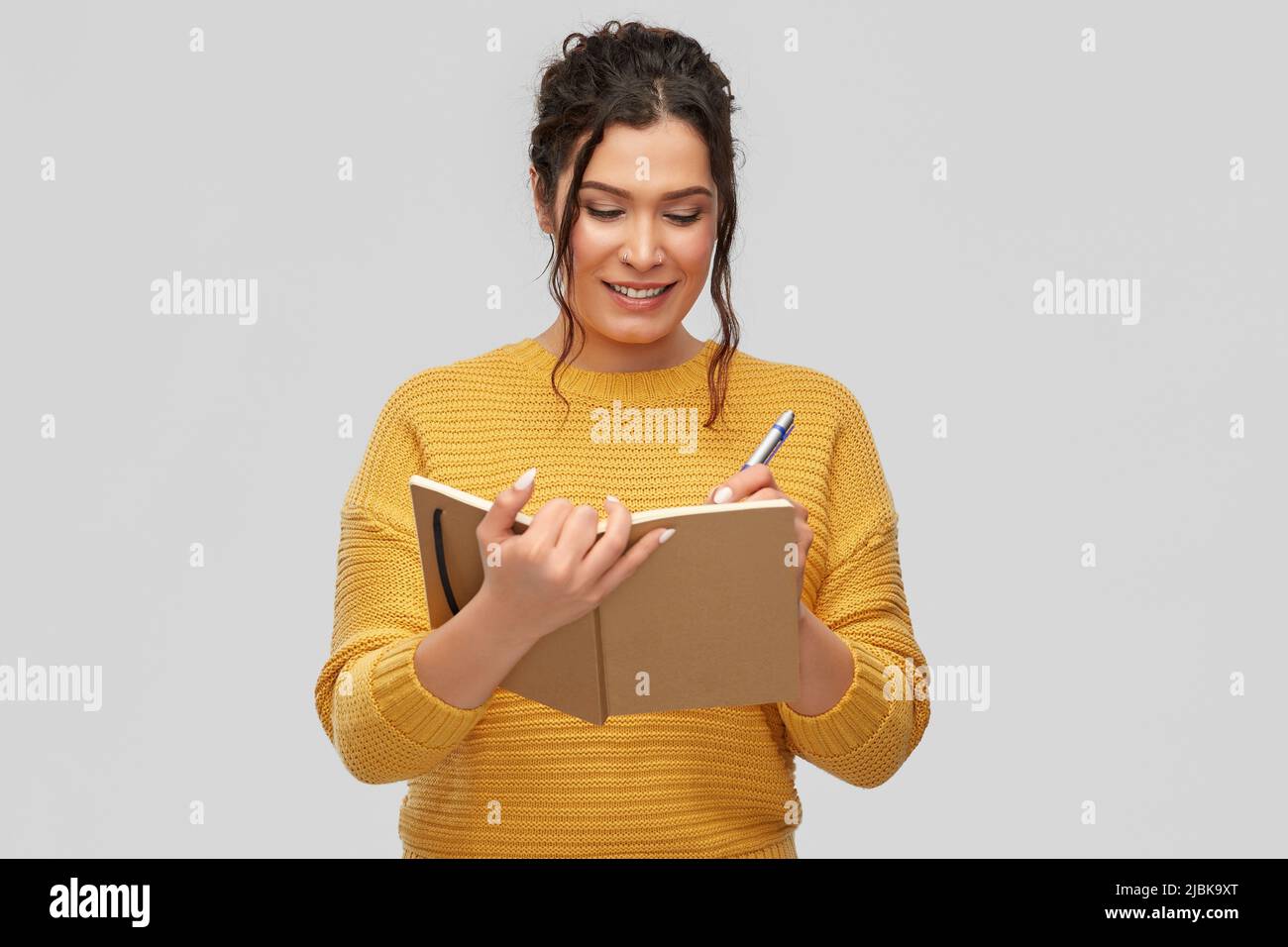 happy young woman writing to diary or notebook Stock Photo
