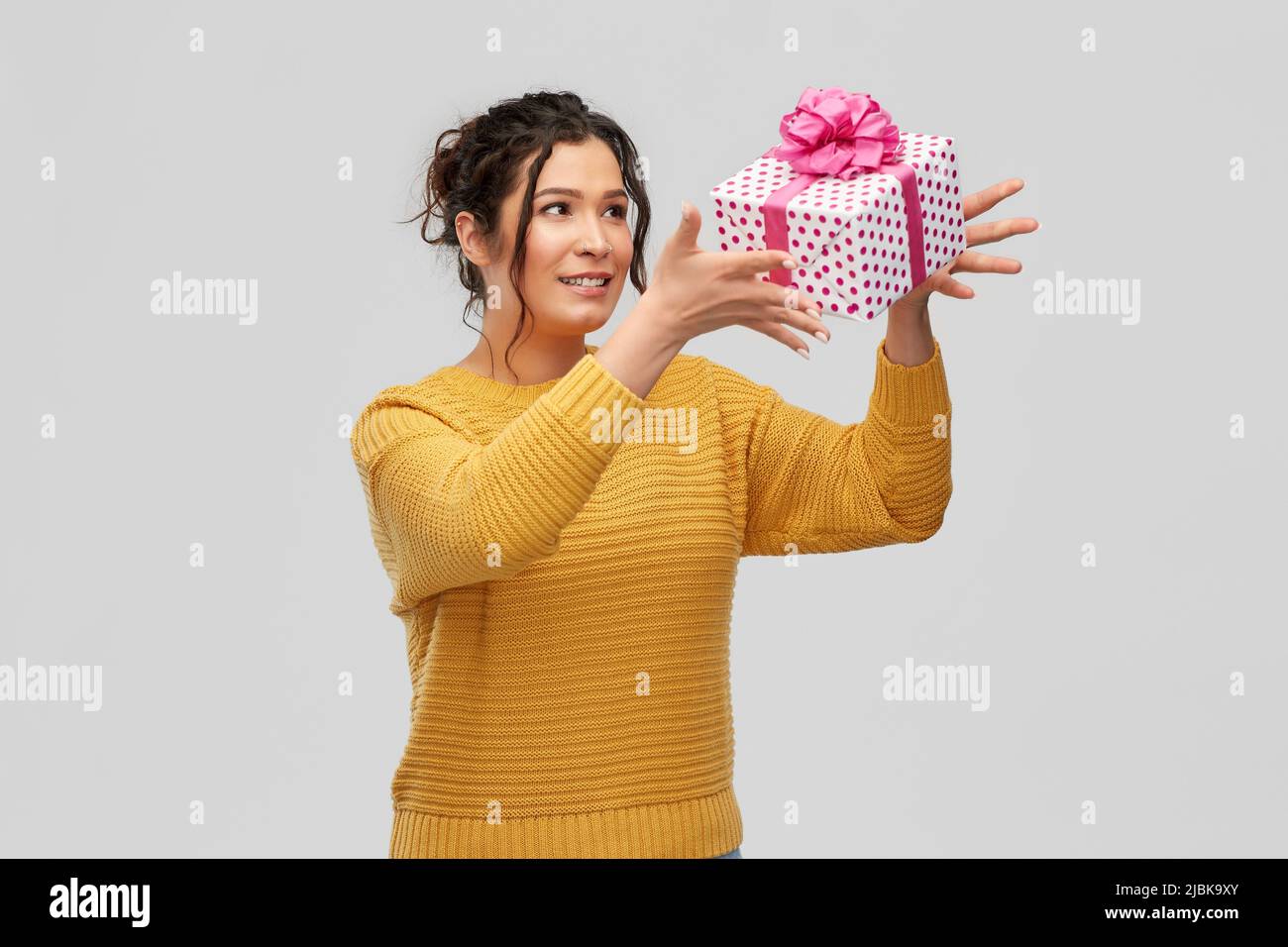 smiling young woman throwing gift box Stock Photo