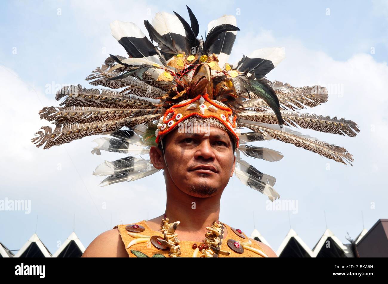 Jakarta, Indonesia - April 28, 2013 : Man from the Dayak tribe of Borneo, Indonesia, wears a headdress with eagle feathers and hornbill beak Stock Photo
