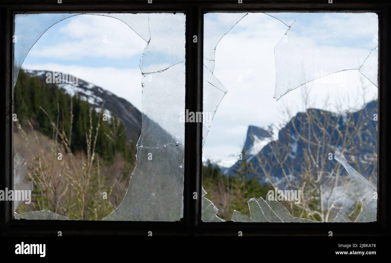 Broken window in derelict building in rural Norway. The area has had a large population decline and many properties are abandoned. Stock Photo