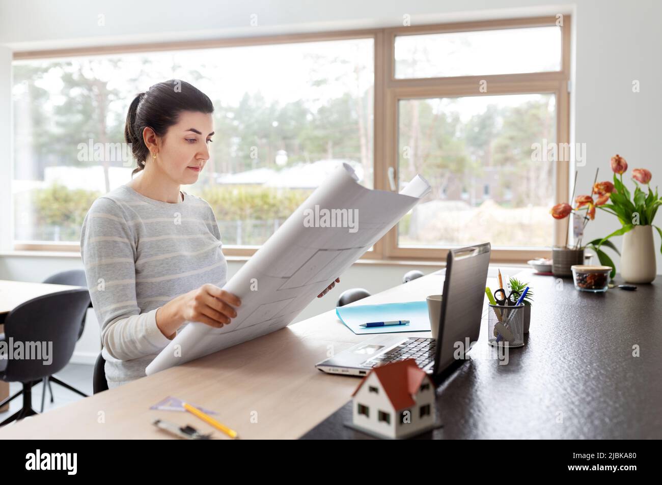 young woman with blueprint working at home office Stock Photo