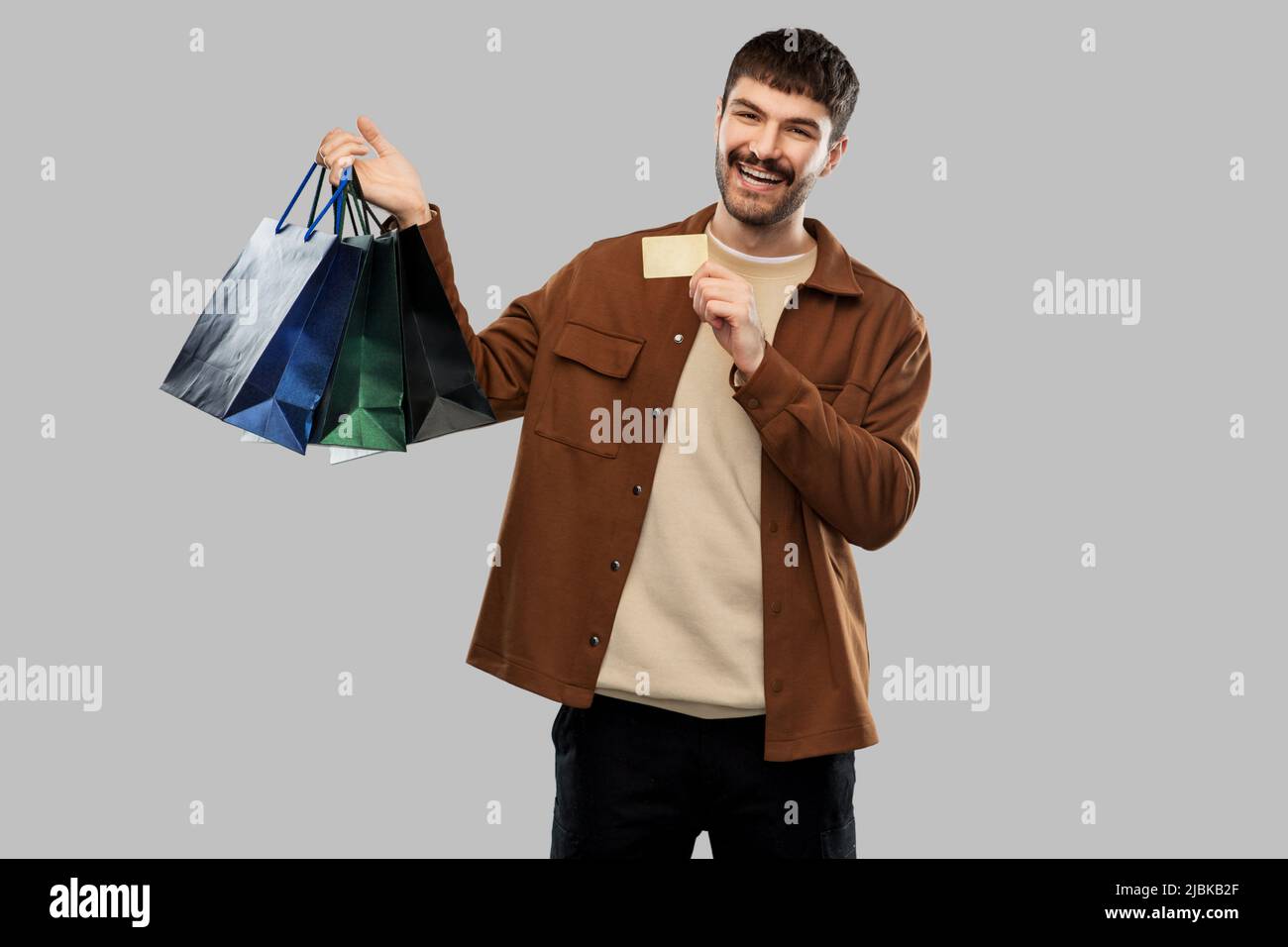 happy young man with shopping bags and credit card Stock Photo