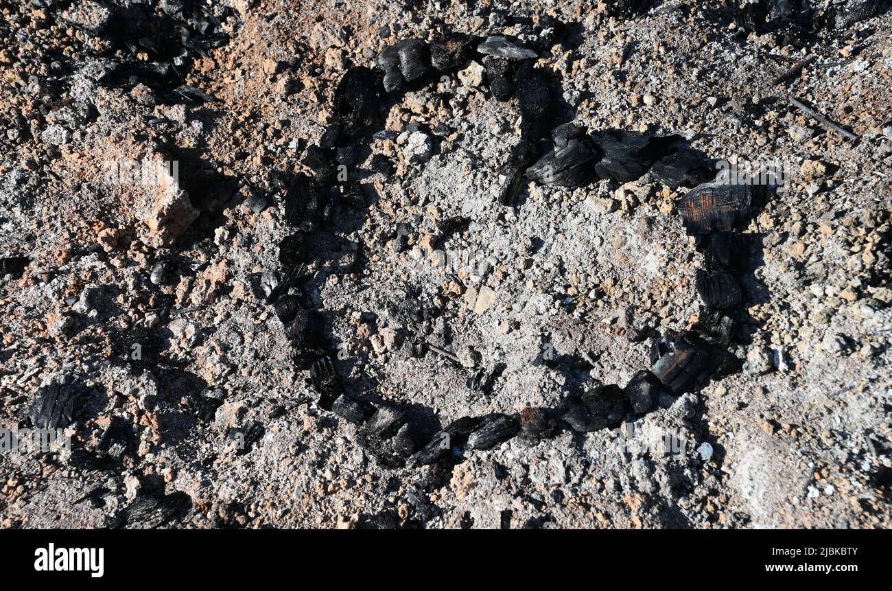 A charcoal heart in the ashes of a fire pit, a black charcoal heart Stock Photo