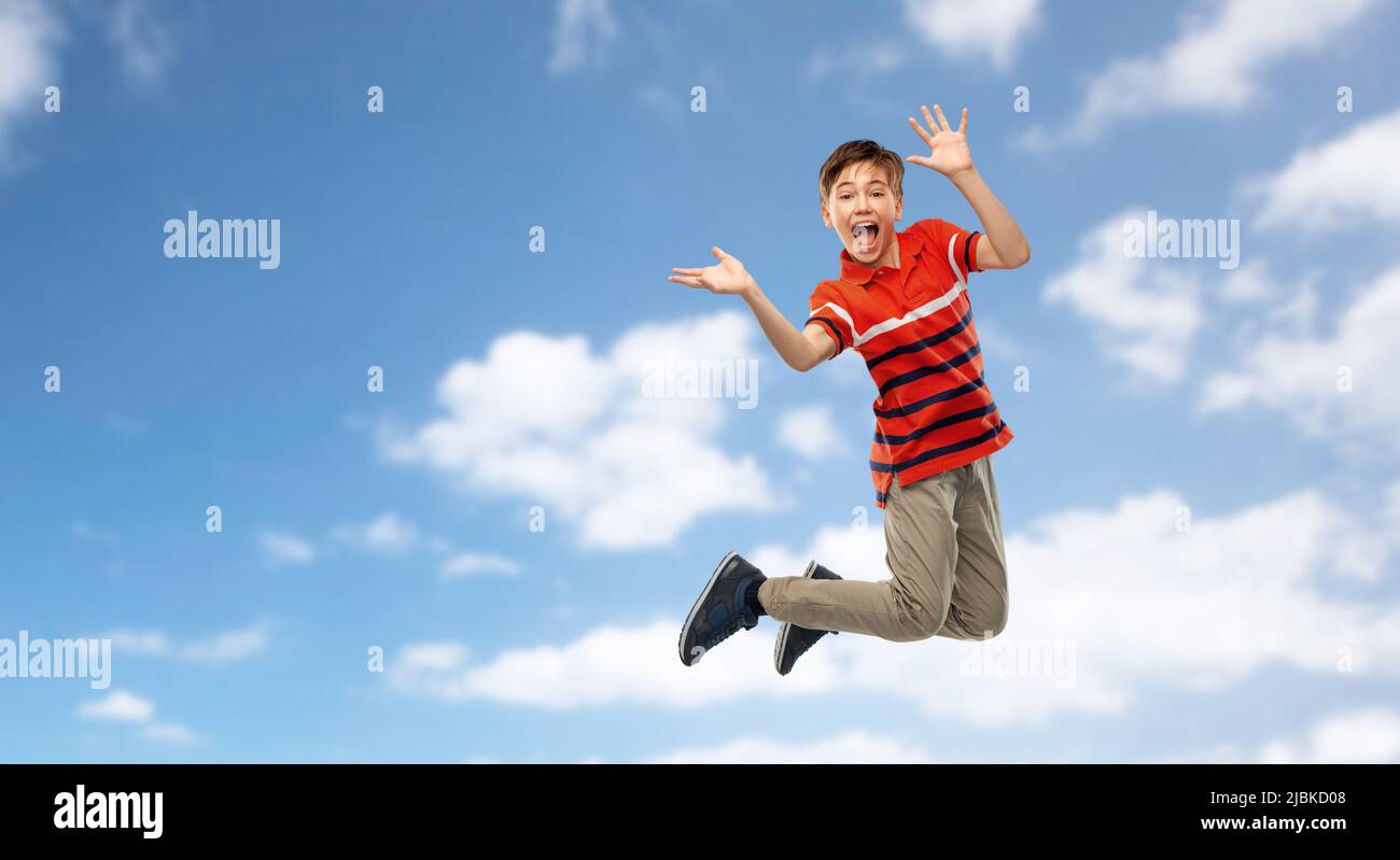 happy smiling young boy jumping in air over sky Stock Photo