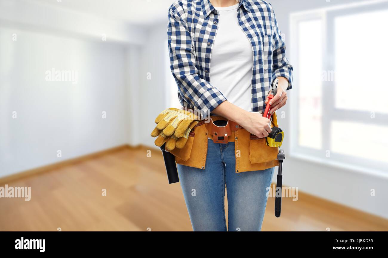 woman or builder with working tools on belt Stock Photo