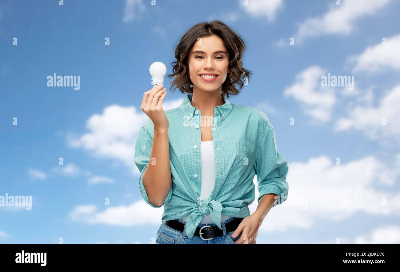 smiling woman holding energy saving lighting bulb Stock Photo