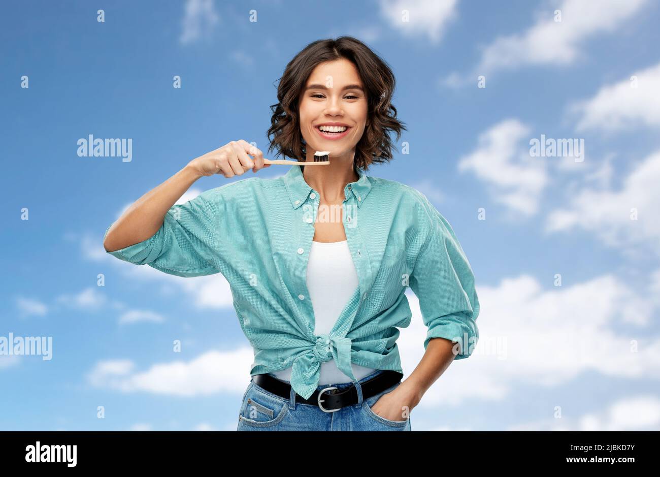 smiling woman with toothpaste on wooden toothbrush Stock Photo
