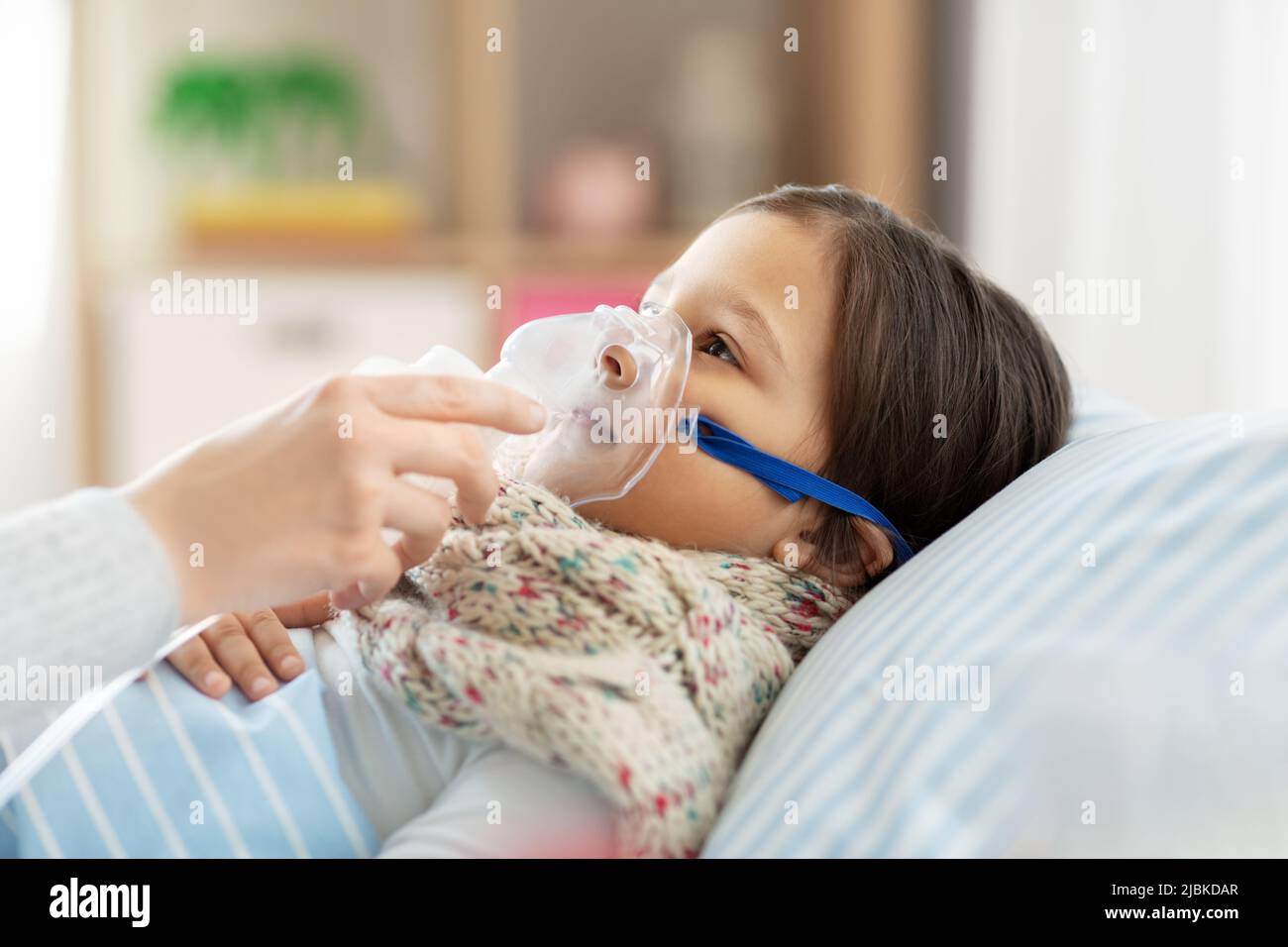 mother and sick daughter with oxygen mask in bed Stock Photo