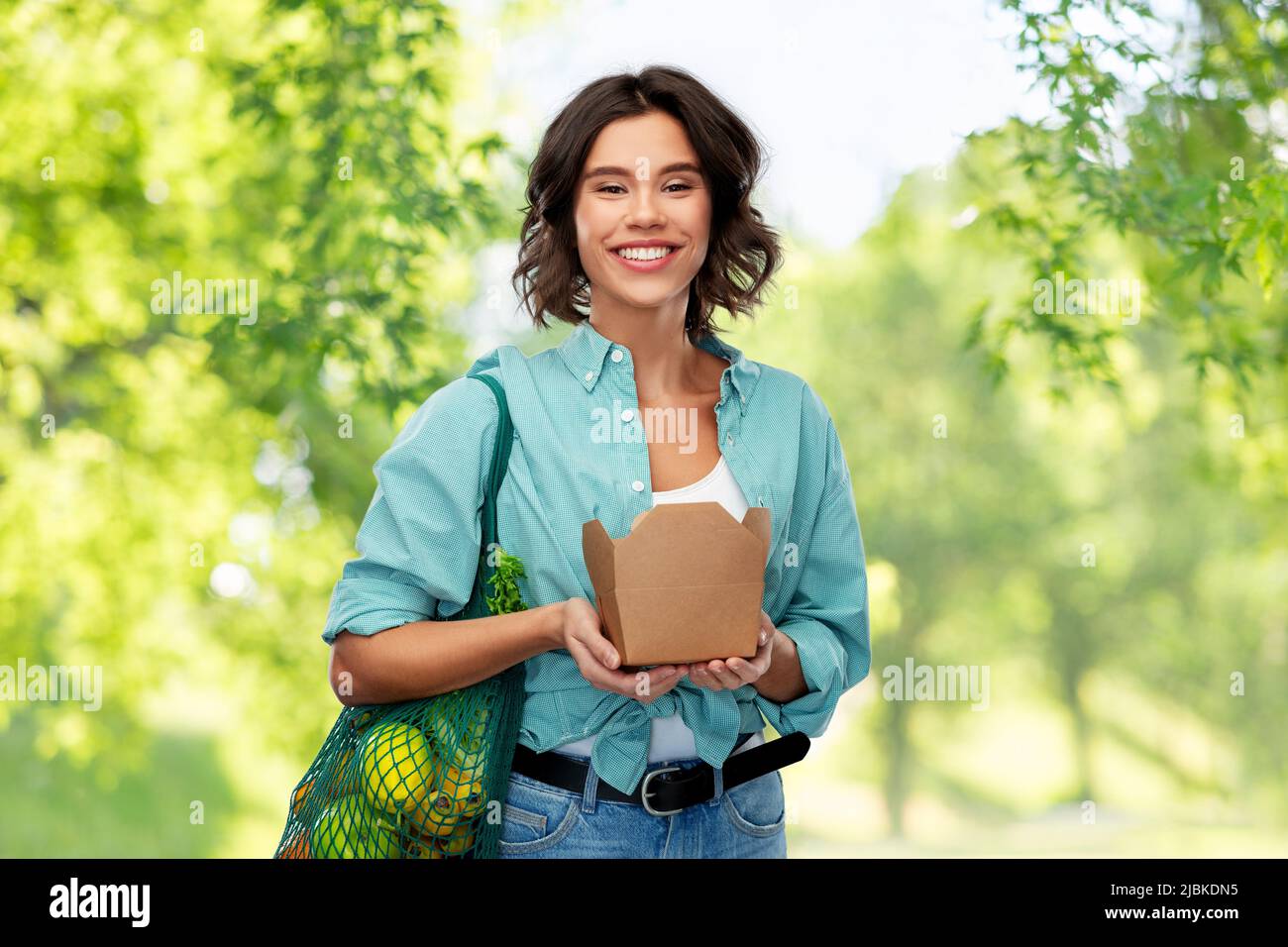 happy woman with food in reusable net bag and wok Stock Photo