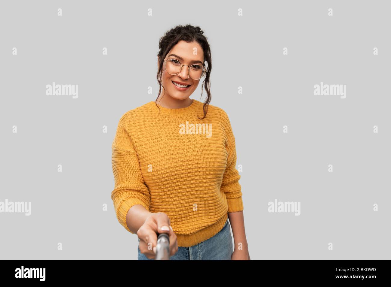 smiling woman taking picture with selfie stick Stock Photo