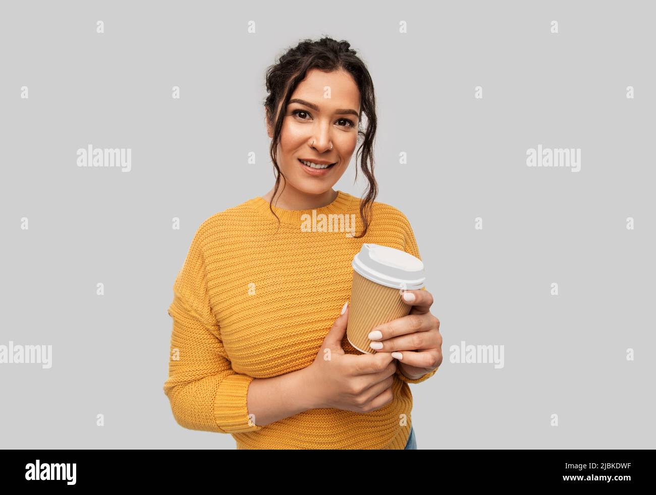 smiling woman with pierced nose holding coffee cup Stock Photo