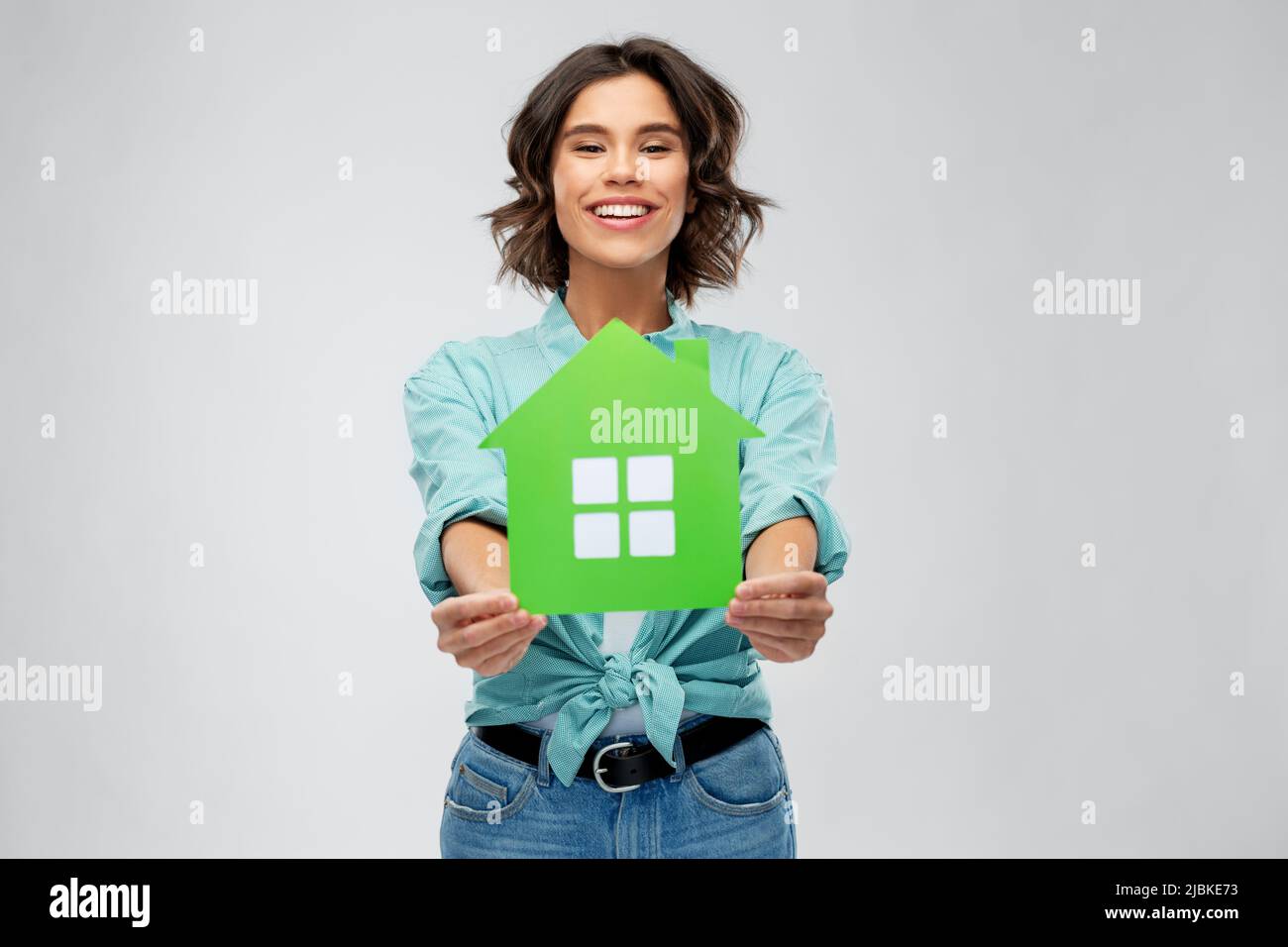 smiling young woman holding green house Stock Photo