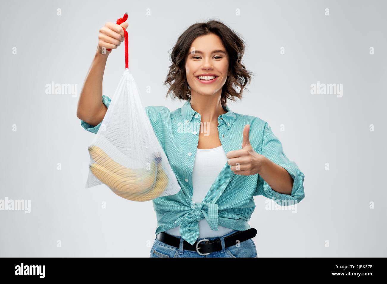 happy woman with bananas in reusable string bag Stock Photo