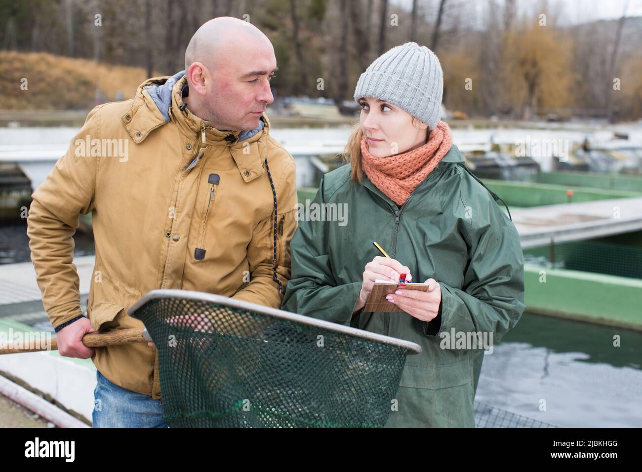 Owner of sturgeon farm giving instruction to female Stock Photo Alamy