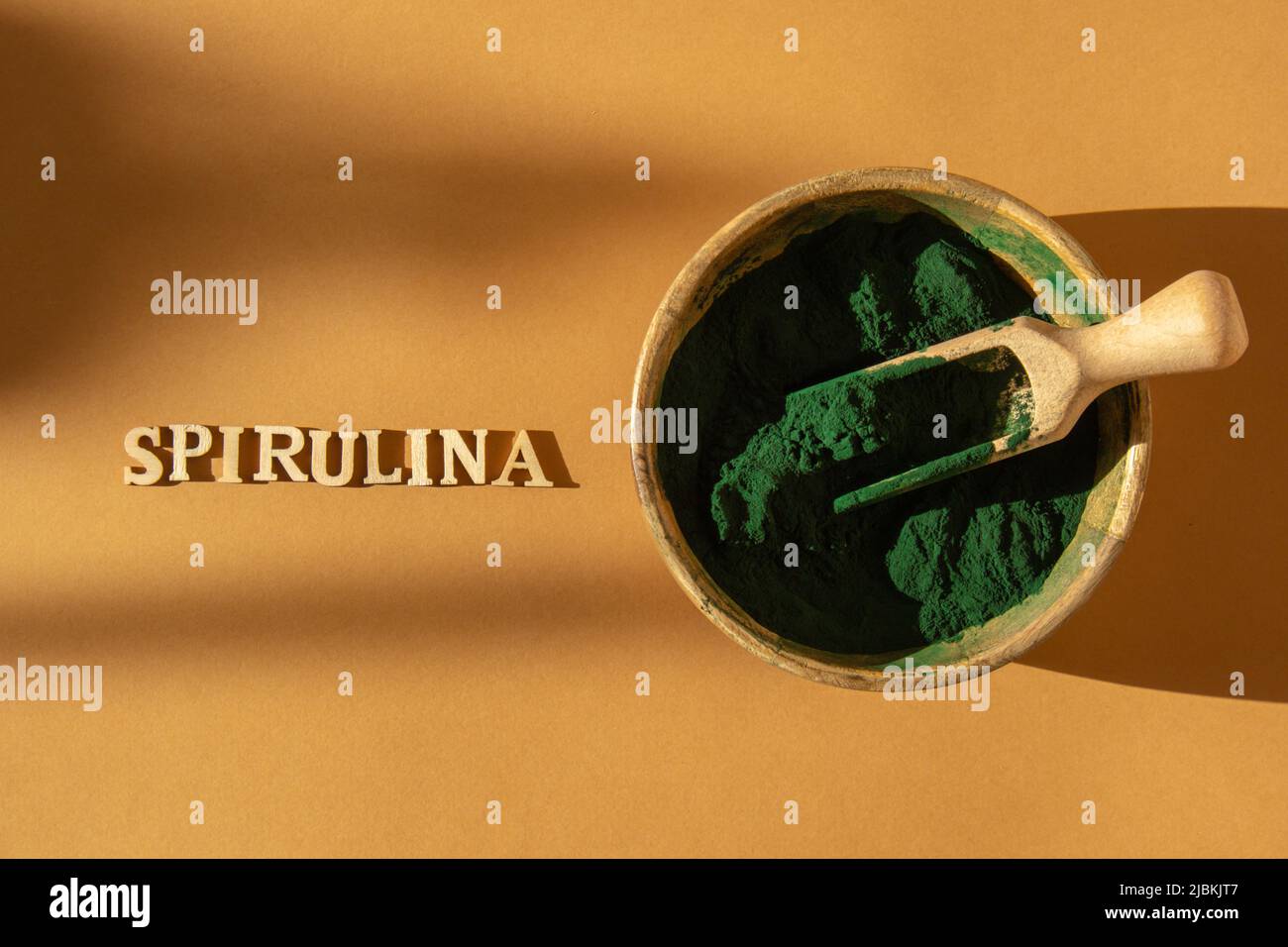 Bluegreen algae spirulina powder in bamboo eco bowl with text