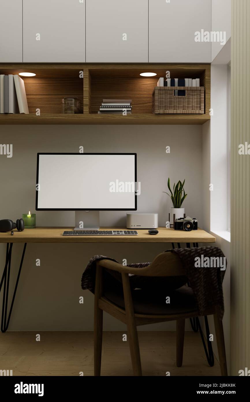 Minimal comfortable Scandinavian home workspace interior design with computer mockup on wood table under minimal wood wall cabinet and wood armchair. Stock Photo