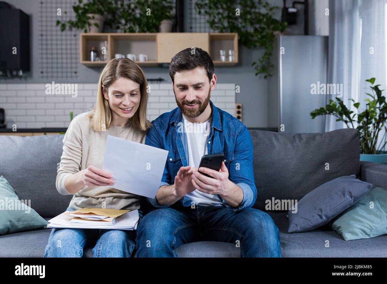 Family sitting on couch paying bills hires stock photography and