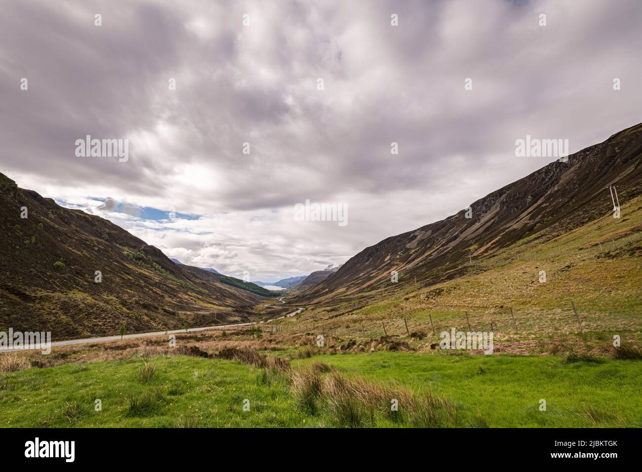 A cloudy, summer, HDR landscape image looking down Glen Docherty to Loch Maree in Wester Ross, Scotland. 23 May 2022 Stock Photo