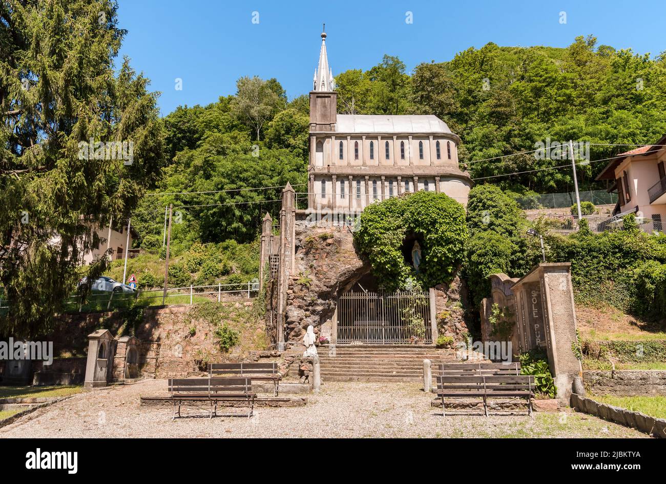 Reproduction of the cave of Lourdes and the Sanctuary in front of Abbey in Ganna, Valganna, province of Varese, Italy Stock Photo