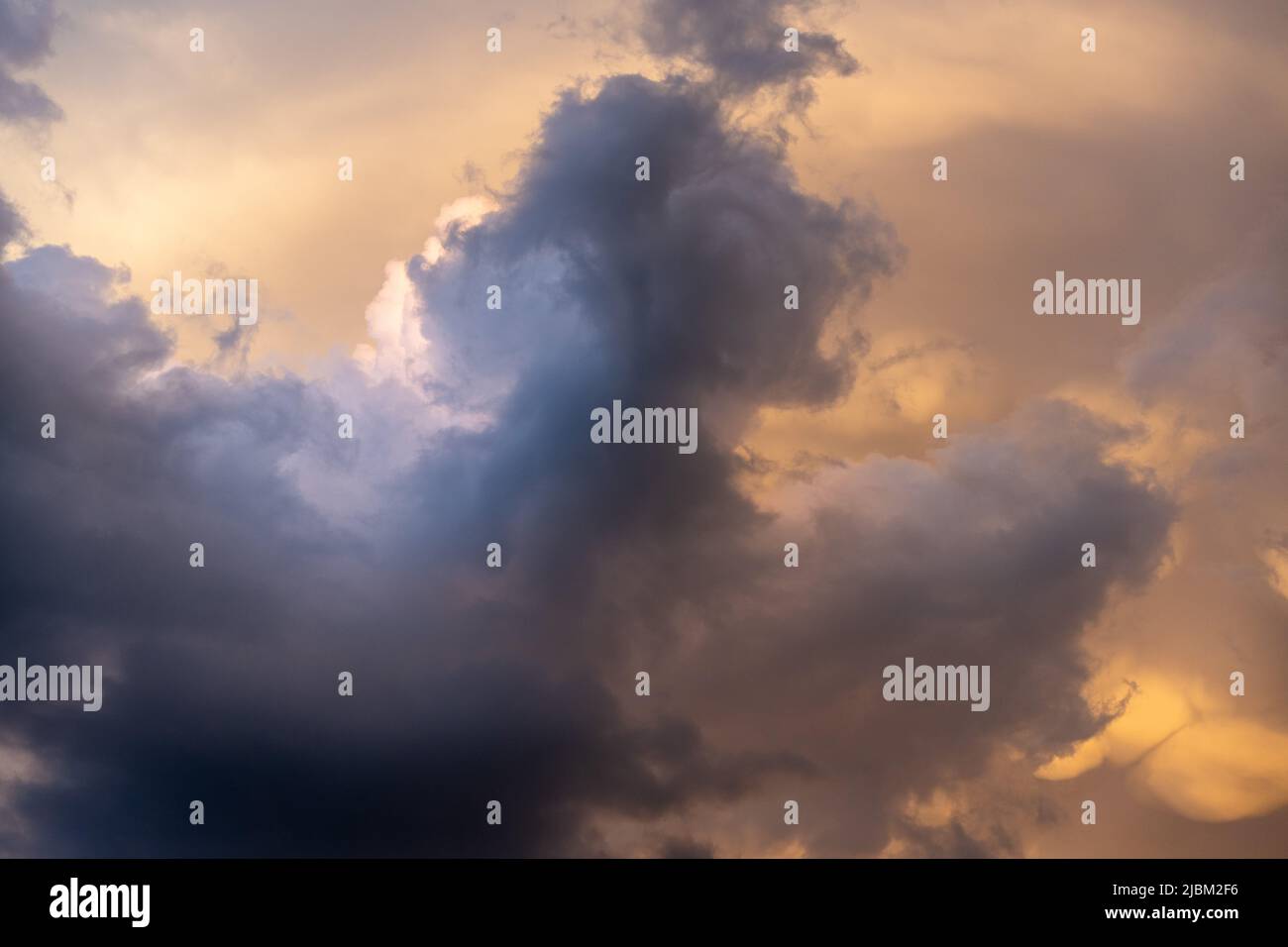 Amazing cumulus clouds before a heavy thunderstorm in the austrian mountains while sunset. Stock Photo