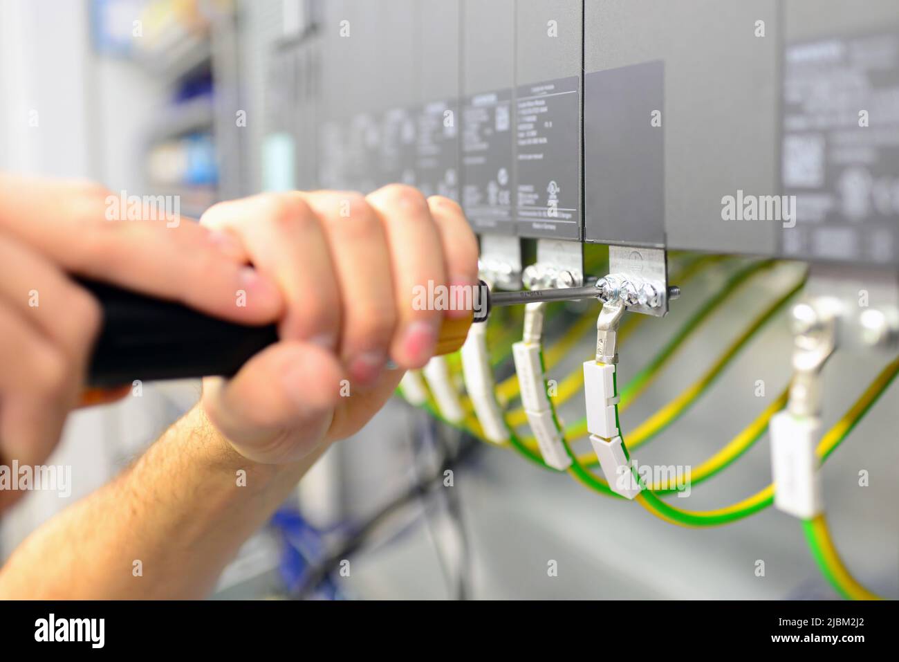 assembly components and cables in a factory in a control cabinet - workplace industry with future - closeup with hand and tools Stock Photo