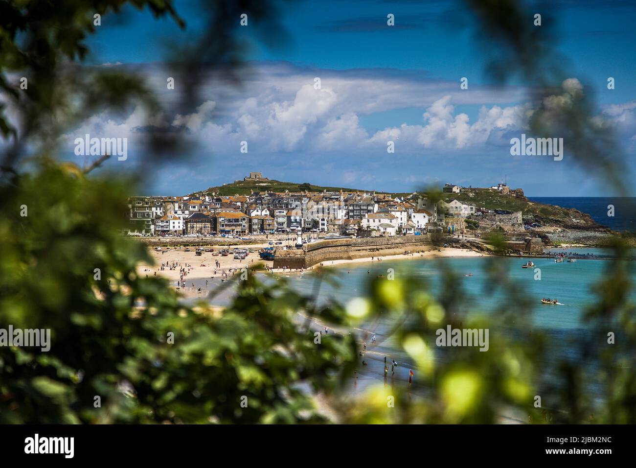 A view of St Ives bay through the green foliage of Carbis Bay, Cornwall, UK Stock Photo