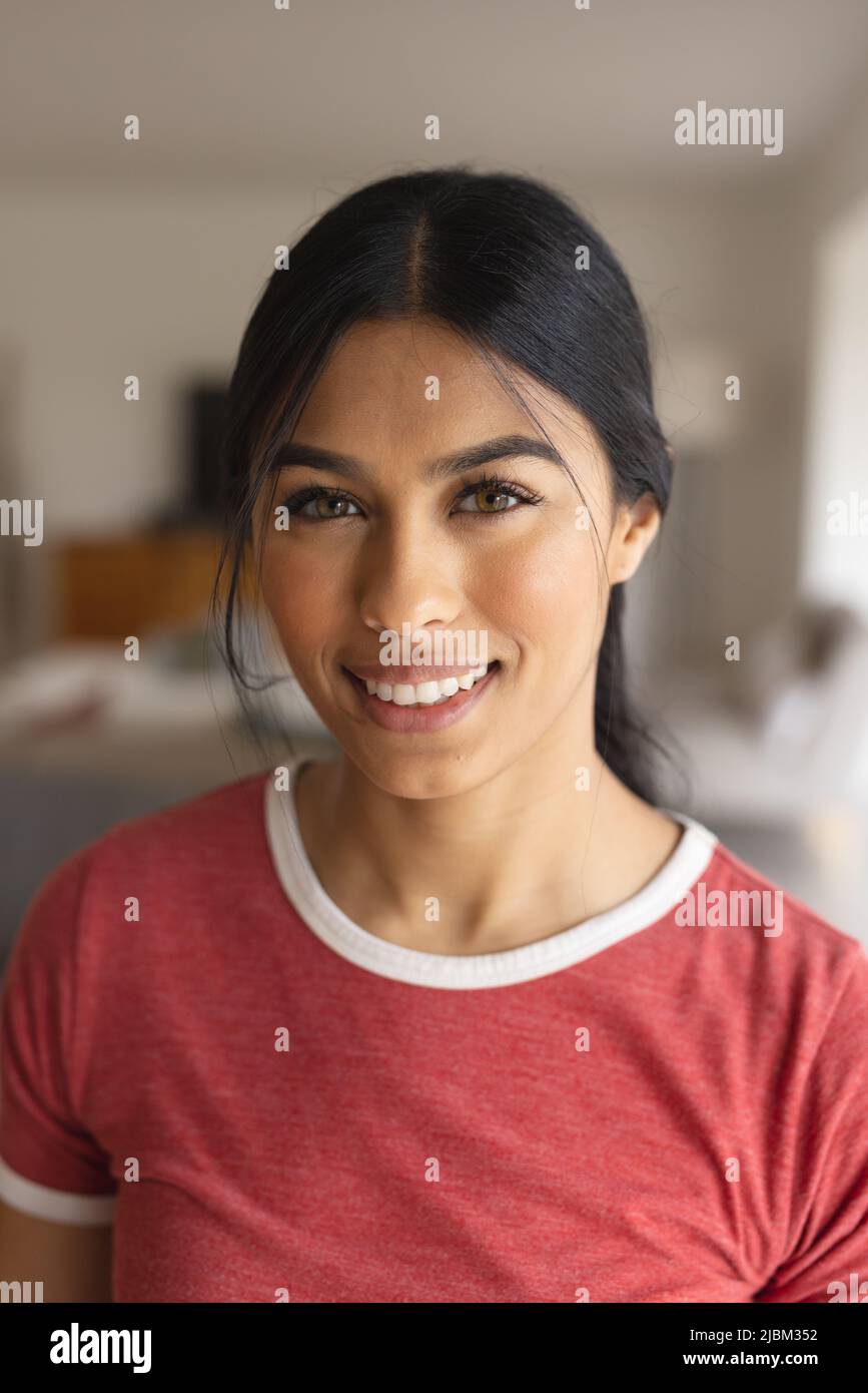 Close-up portrait of beautiful biracial young woman smiling at home Stock Photo
