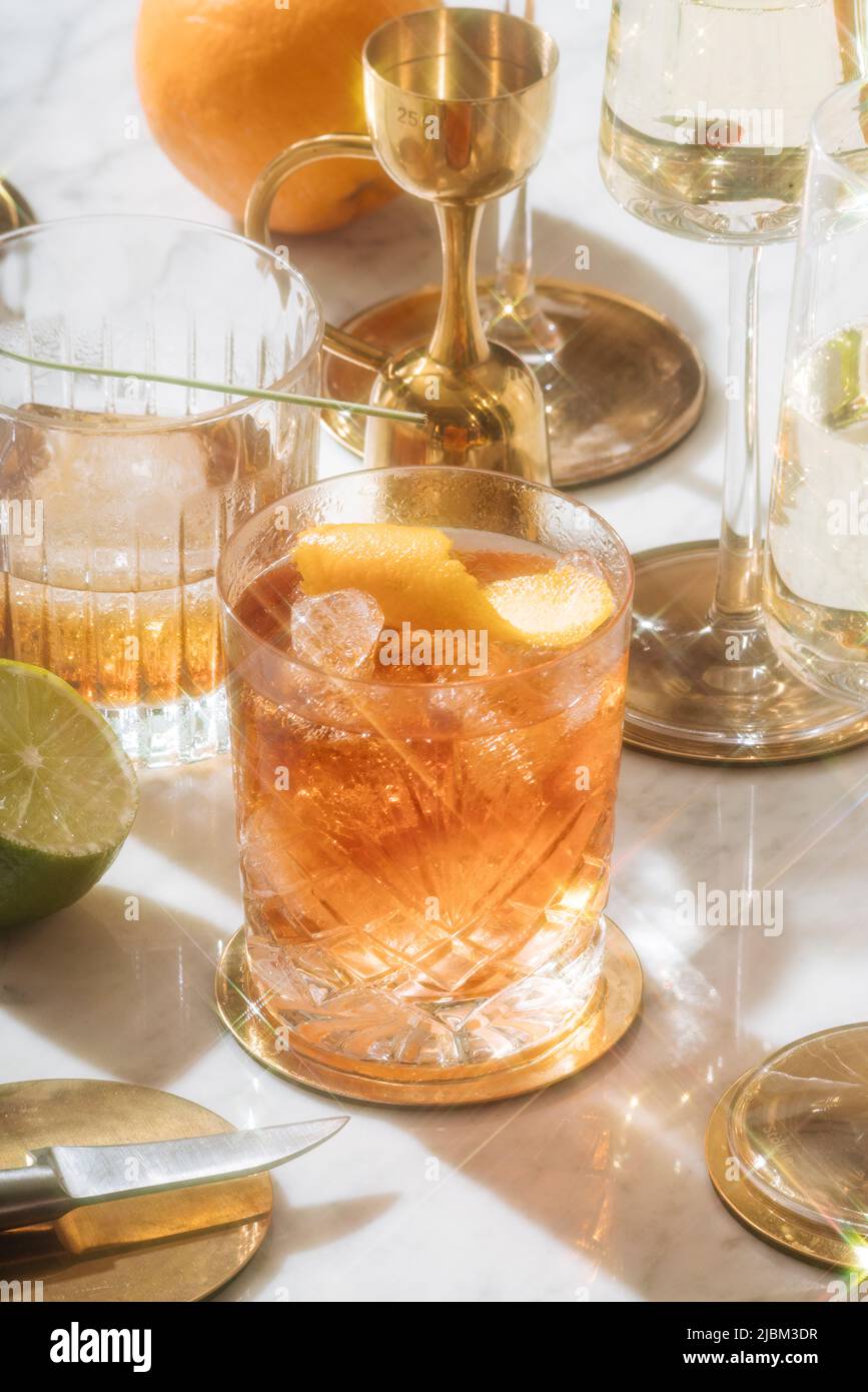 Negroni cocktail (garnished with orange peel), between martinez and prosecco Stock Photo