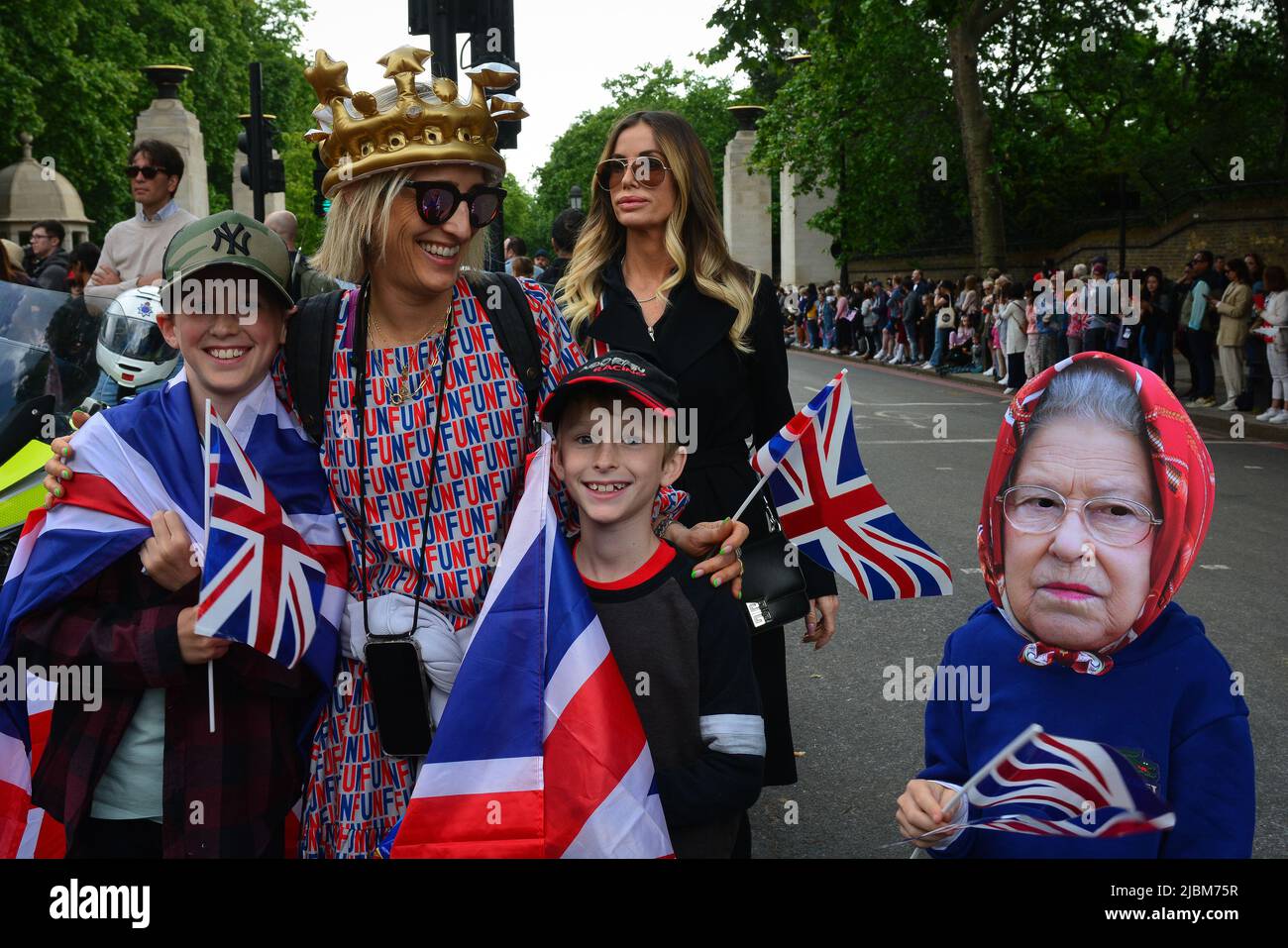 London, UK. 02nd June, 2022. A woman and two children hold flags and pose near a person wearing a Queen Elizabeth mask during Queen Elizabeth's Platinum Jubilee held in London, England on June 2, 2022. Thousands of people have turned out in central London as celebrations begin for the Queen's Platinum Jubilee. (Photo by Laura Chiesa/Pacific Press/Sipa USA) Credit: Sipa USA/Alamy Live News Stock Photo